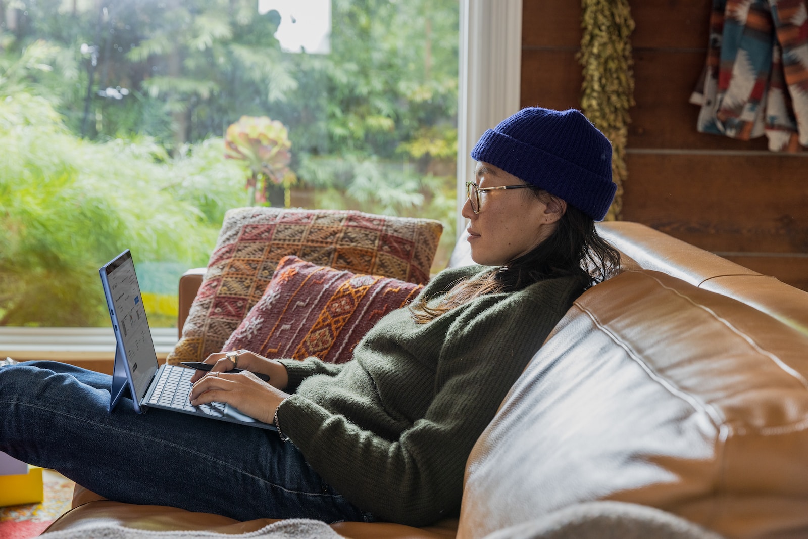 A Person Sitting At A Table Using A Laptop